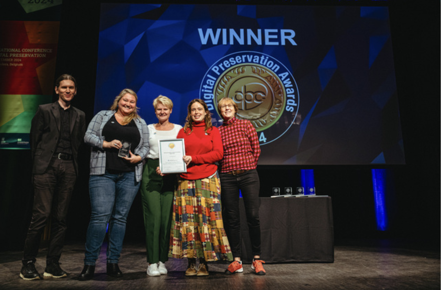 Judges Matthew Burgess and Marjolein Steenman presenting us the Digital Preservation Award for Teaching and Communications, during the Digital Preservation Awards Ceremony in Ghent (iPRES2024).